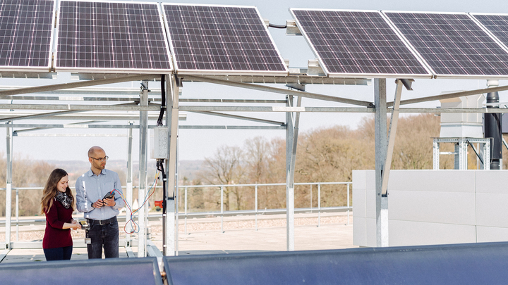 Zwei Personen  auf dem Dach der HSBI vor der Photovoltaikanlage